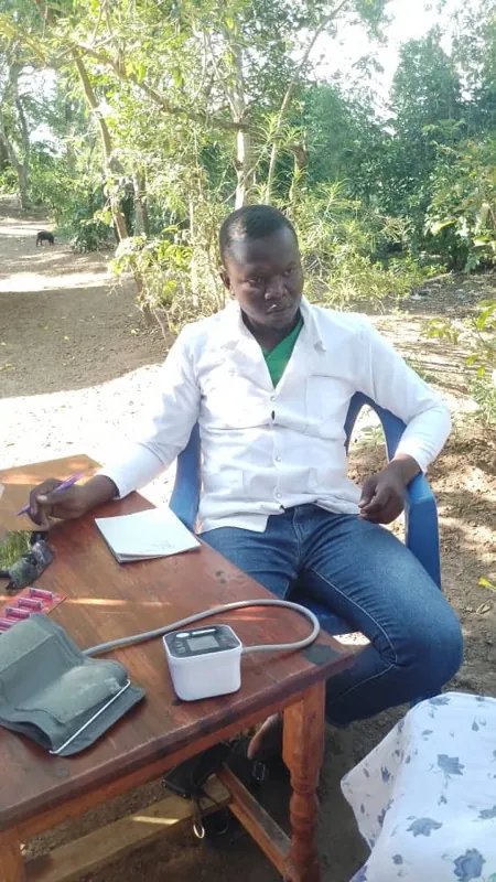 Dr. Saviour, der Mobile Doctor, mit Blutdruckmessgerät an einem Tisch im Freien